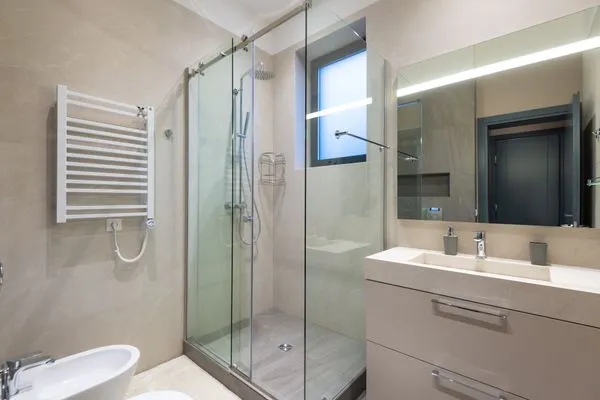 Baño renovado con box de ducha de vidrio templado