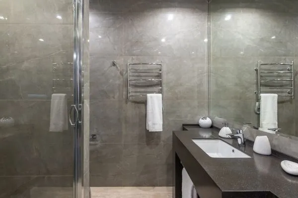 Baño minimalista renovado con ducha de vidrio