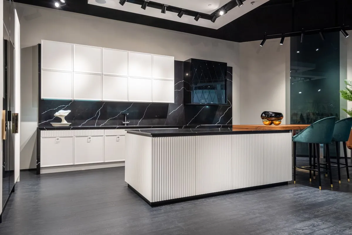 Cocina remodelada blanca con isla central y mesada oscura