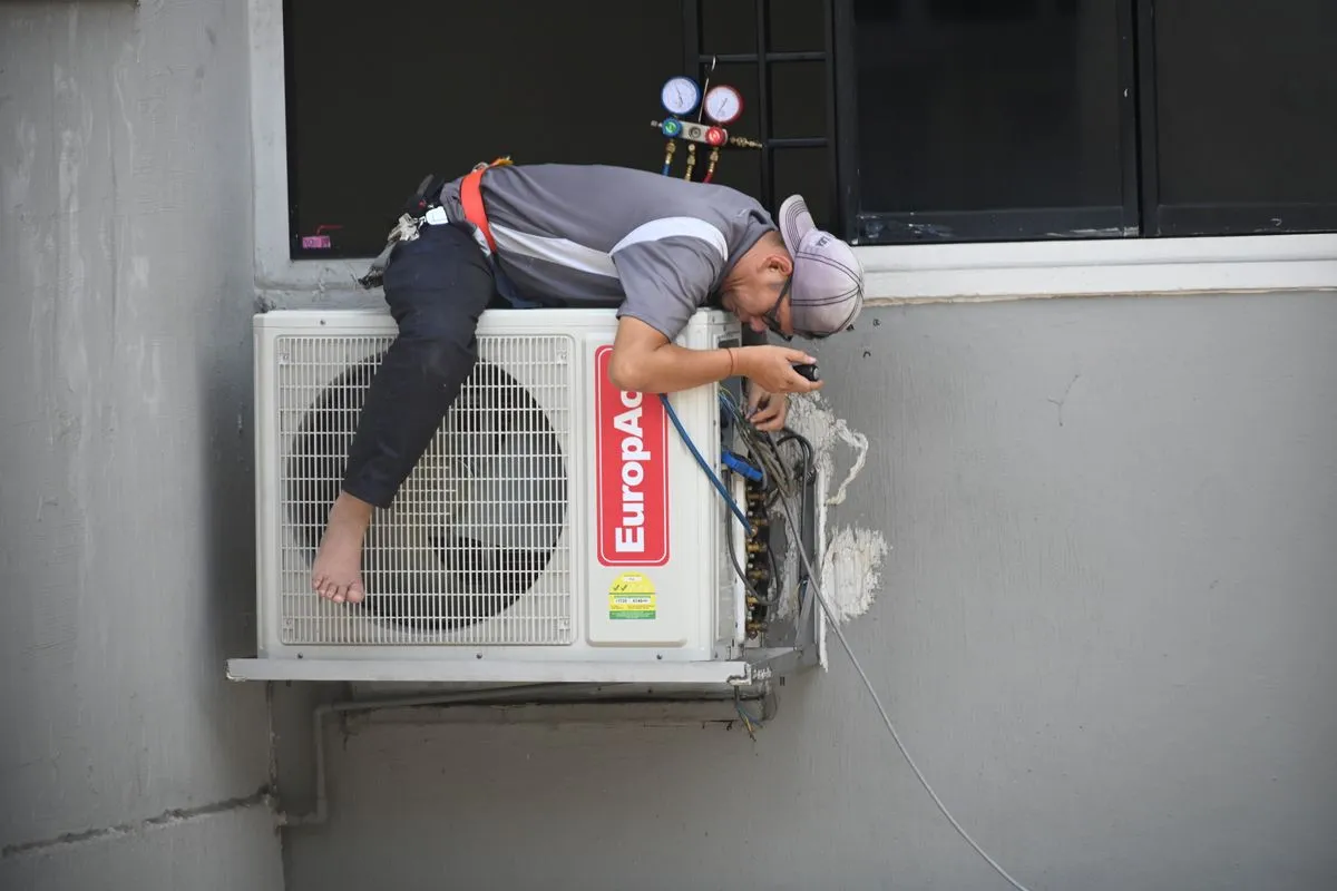Técnico instalando la unidad exterior de un aire acondicionado